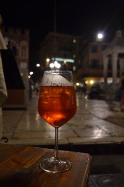 Verona Meydanı 'nın arka planında bir bardak Spritz kuyruk.