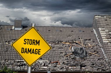 sarı hasar uyarı işareti önünde, ağır kasırga tornado fırtına tarafından hasarlı evin çatısı