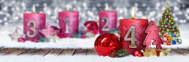dördüncü Pazar advent kırmızı mum altın metal bir gümüş panorama bokeh arka plan kar öndeki ahşap plakalar ile