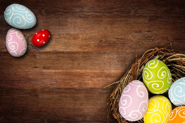 Colorful happy easter eggs in bird nest and tulips on dark empty — Stock Photo, Image