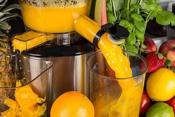 Slow juicer in keuken met veel fruit en plantaardige oranje vita — Stockfoto