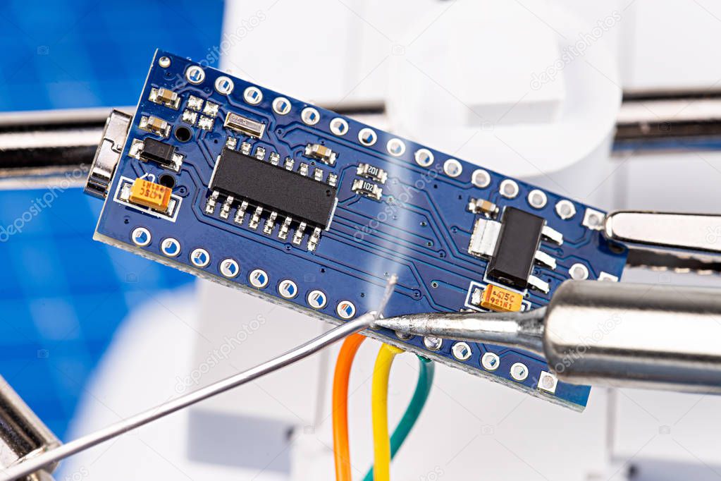 Soldering pins and wires with iron tool of blue micro controller