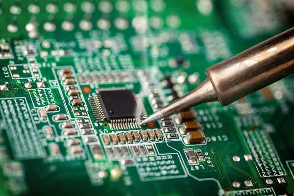 Soldering a micro chip processor with iron tool green circuit bo — Stock Photo, Image