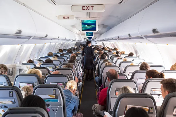 Внутрішній погляд на пасажирів і членів кабінного екіпажу на авіасалоні авіакомпанії — стокове фото