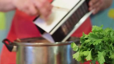 Rende Cook'u zencefil kökü losyonları. Aşçı zencefil kökü üzerinde rende losyonları. Belirsiz arka plan.