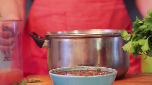Il cuoco versa il succo da un decanter in una pentola . — Video Stock