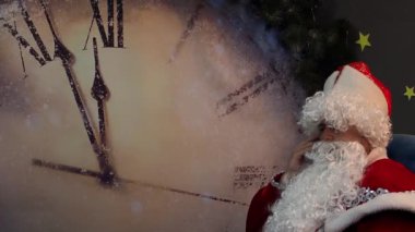 Babası Frost telefonla konuşuyor. Peri masalı yeni yıl ve Noel karakter büyük saatin arka planı bir sandalyede oturuyor. Telefonla iletişim kurar.