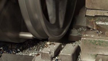 Büyük metal detayların üretimi makinede. Üretim sırasında metal tıraş partiler üzerinde uçar. Yakın çekim.