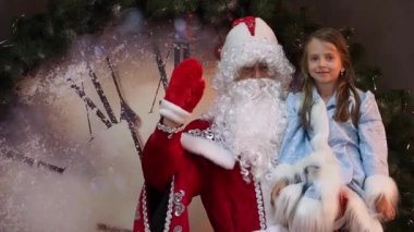 Neşeli çocuk ve babası Frost hoş geldiniz el dalgalar. Bir çocuk Noel arifesinde tatil. Yılbaşı karakterleri büyük saat arka planı.