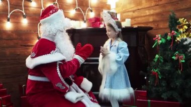 Babası Frost Noel Baba ve küçük kız Snegurochka avuç içi oynamak. Yeni yıl Noel masal karakterleri Rus geleneği oyun pat-a-pasta bir şömine ve köknar ağacı.