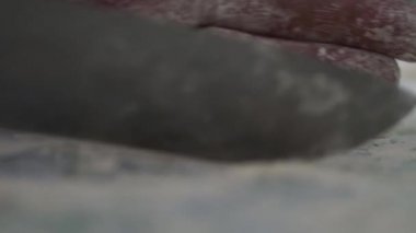 Bir el ve bir bıçak cheesecake adam formlar. Yakın çekim. Bir bıçak bir un ürün şeklinde aşçı formlar.