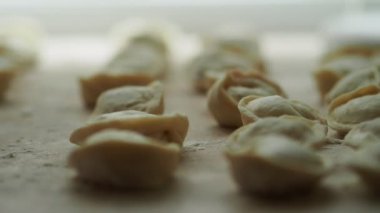 Mantı çok. Sağdaki soldaki görünümü. Yarı bitmiş ürünler bir masada yalan. Yakın çekim.