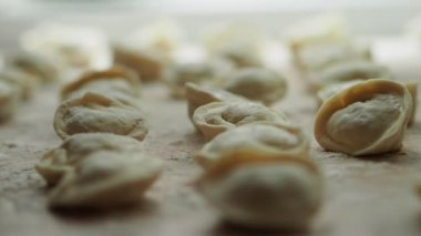 Mantı çok. Sağdaki soldaki görünümü. Yarı bitmiş ürünler bir masada yalan. Yakın çekim.