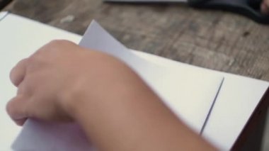 Kadın bir parça kağıt ikiye keser. Yaratıcı çalışma kağıt ile. Makas kağıt. Yakın çekim. Retro tarzı.