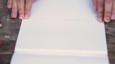 Kadın kağıt yaprağının ikiye koyar ve o uzakta bir temel gözyaşları. Yaratıcı çalışma kağıt ile. Makas kağıt. Yakın çekim. Retro tarzı.