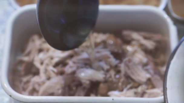 Aus einer Kelle fette Brühe auf Stücke gekochten Fleisches gießen. — Stockvideo