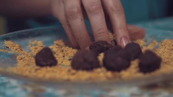 The girl forms chocolate balls with powder. — Stock Video