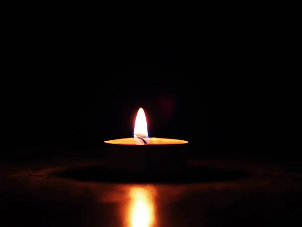 In the dark there burns a small candle. — Stock Photo, Image