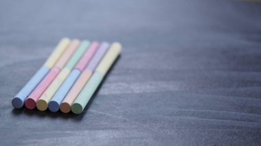 Siyah okul Kurulu yüzeyinde renkli boya kalemleri.
