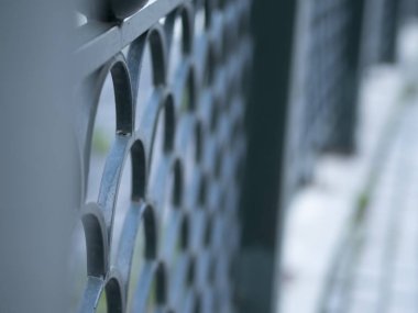 Şehir caddesinde dövme metal çit. Yumuşak seçici odak. Bulanık ön plan ve arka plan.