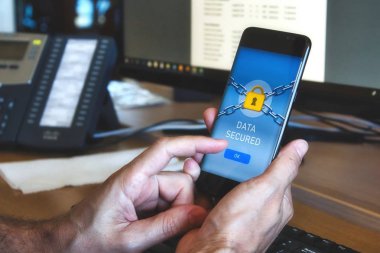 Sarı asma kilit görüntüleme ve parmak ile Ok butonuna basarak bir veri güvenlik uygulaması ile mobil bir akıllı telefon tutan adam