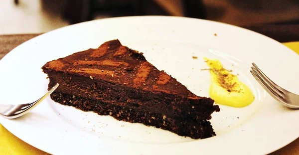 Chocolate cake dessert on a white plate with forks to share between two people