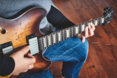 Elektrikli yarı boş gitar çalan bir kadın.