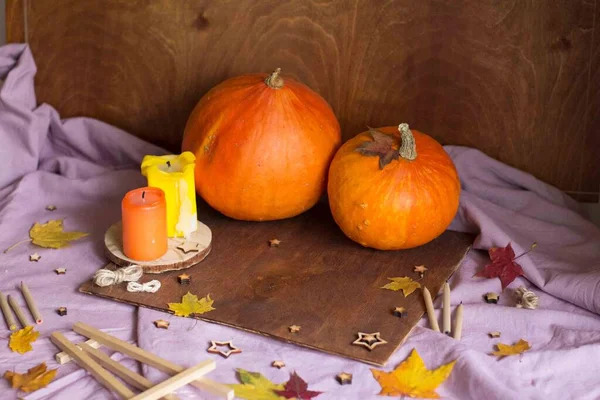Festive autumn decor with pumpkins. Drawing on the background of autumn decor and autumn leaves. Autumn home decor.