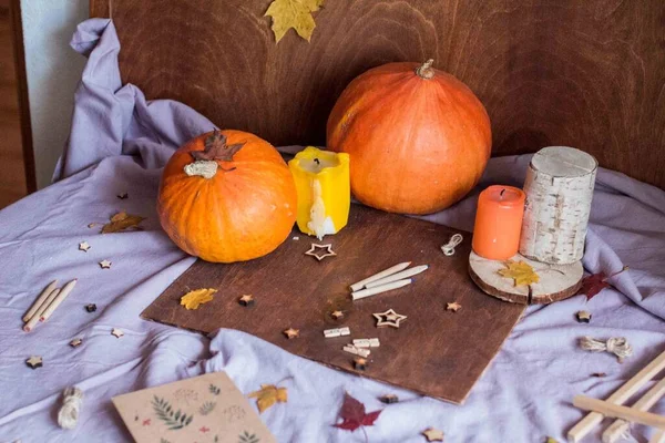 Festive autumn decor with pumpkins. Drawing on the background of autumn decor and autumn leaves. Festive autumn decor with pumpkins.