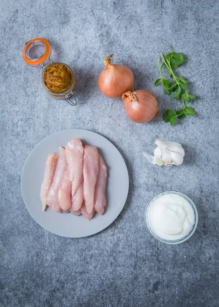 灰色の背景とチキンカレーの材料 チキン カレー ペースト の玉ねぎ ハーブの部分のプレート ニンニクとヨーグルト 皿に鶏肉 — ストック写真