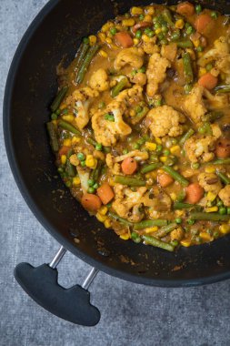 Derin siyah bir tencerede sebze köri görünümünü kapatın. Hint sebze köri üstten görünüm ile açık gri renkli. Sebze masala baharatlar ile. Ev yapımı sebze köri.
