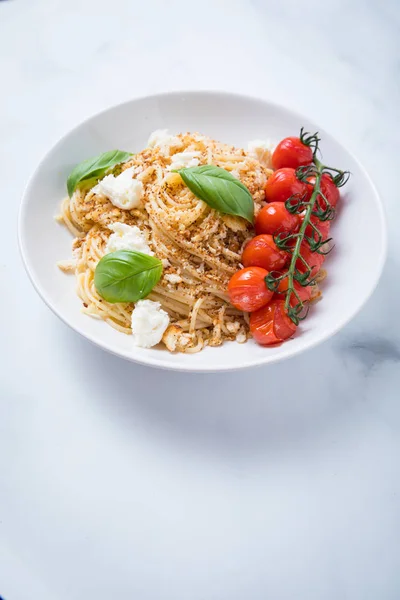 ベジタリアン スパゲッティ パスタ食事味付きパン粉 バジル バジリコ 深い白い場所のロースト チェリー トマトと白背景 — ストック写真