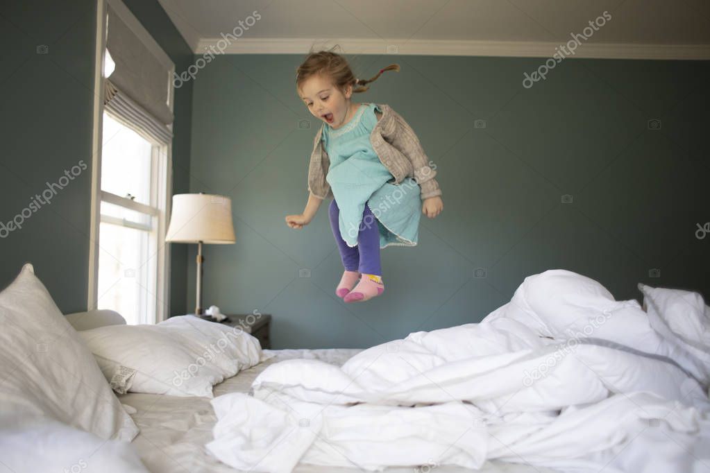 Child jumping on a bed