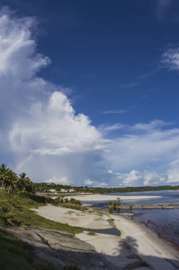 Palmiye ağaçları ile 'Rio Negro' nehir, nehir plaj. Bulutlar ve rainbow ile güneşli gün. Balıkgözü atış. Yani Gabriel da Cachoeira, Amazonas / Brezilya