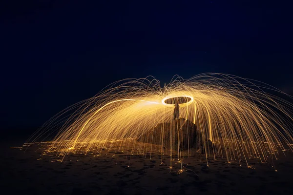 Light trails of fire with steel wool in Xago Beach