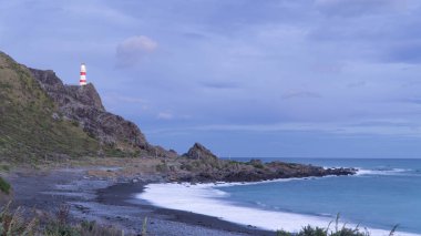 Cape Palliser kayalık uçurum tepesinde Yeni Zelanda günün sonunda bulunan deniz feneri