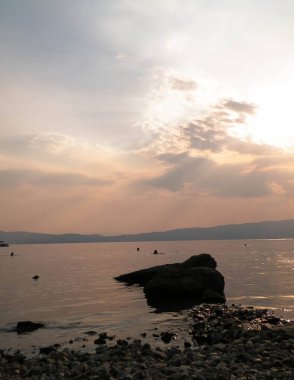 Ochrid Gölü üzerinde gün batımı. Ochrid Gölü 'nün güzel sularındaki güneşin yansıması. Doğadaki güzellik kavramı.