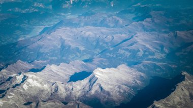 Alpler, uçağın penceresinden dağların manzarası. Toprak bükme ve doğa kavramı.