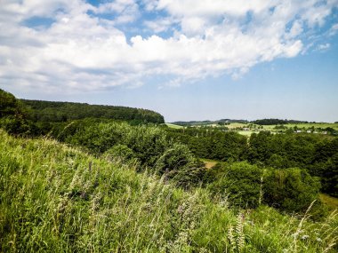Tepeler, tarlalar ve çayırlar. Wiezyca 'nın güzel manzarası, Kashubia Bölgesi, Kuzey Polonya. Boşluğu mavi gökyüzünde kopyala.