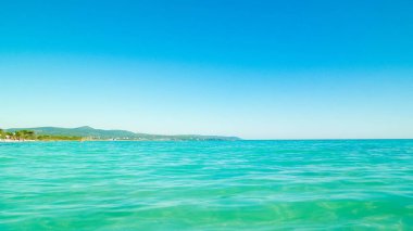 Mavi, şeffaf Tyrhenian deniz suyu mavi gökyüzü arka planında. Tatiller ve doğa konsepti. Boşluğu kopyala.