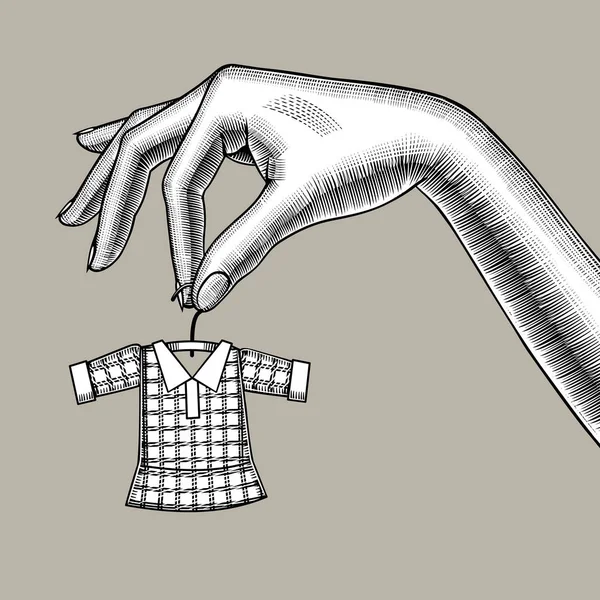 Vrouwelijke hand houden van een kleine kleine jurk op hanger — Stockvector
