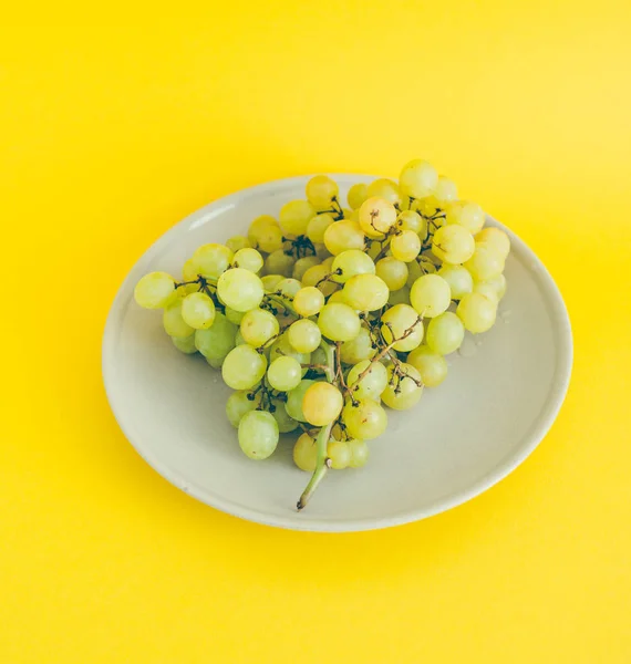 緑の背景に皿の上のブドウ クローズ アップ — ストック写真