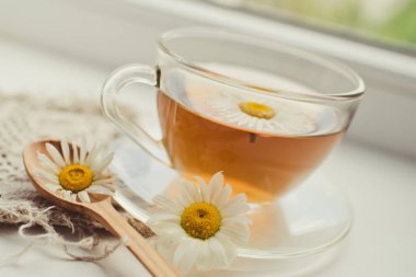 Papatya çiçekli bir fincan çay. 