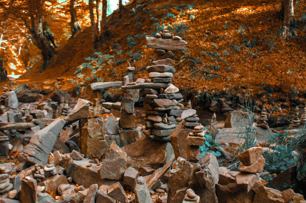 Stones pyramid in autumn mountain forest near river
