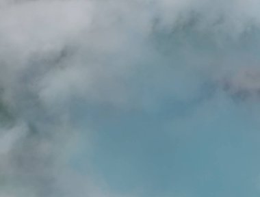 Erken ilkbaharda güneşli bir öğleden sonra puslu küçük cirrostratus, cirrocumulus ve kümülüs bulut oluşumları donuk Avustralya gökyüzüne karşı tezat vardır.