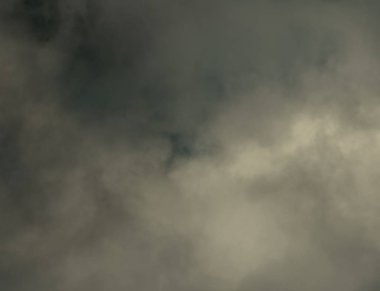 Güneşli bir günde gökyüzündeki karanlık yağmur bulutları. 