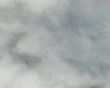 Bulutlu Bir Gökyüzü Boyunca Uçan Küçük Uçak - Beyaz ve gri bulutlar ve bulutlar arasında gösteren bazı mavi gökyüzü ile gökyüzünde uçan küçük bir uçak fotoğrafı.  