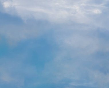  Mavi gökyüzündeki bulutlar yerin üzerinde süzülüyor.