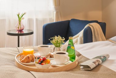 Otel odasında güneşin ışıklı yatağa yalan kahvaltı hizmet. Rahat otel odasında.