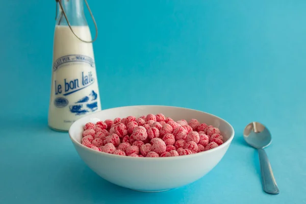 Fun and colorful bowl of pink cereal with blue background